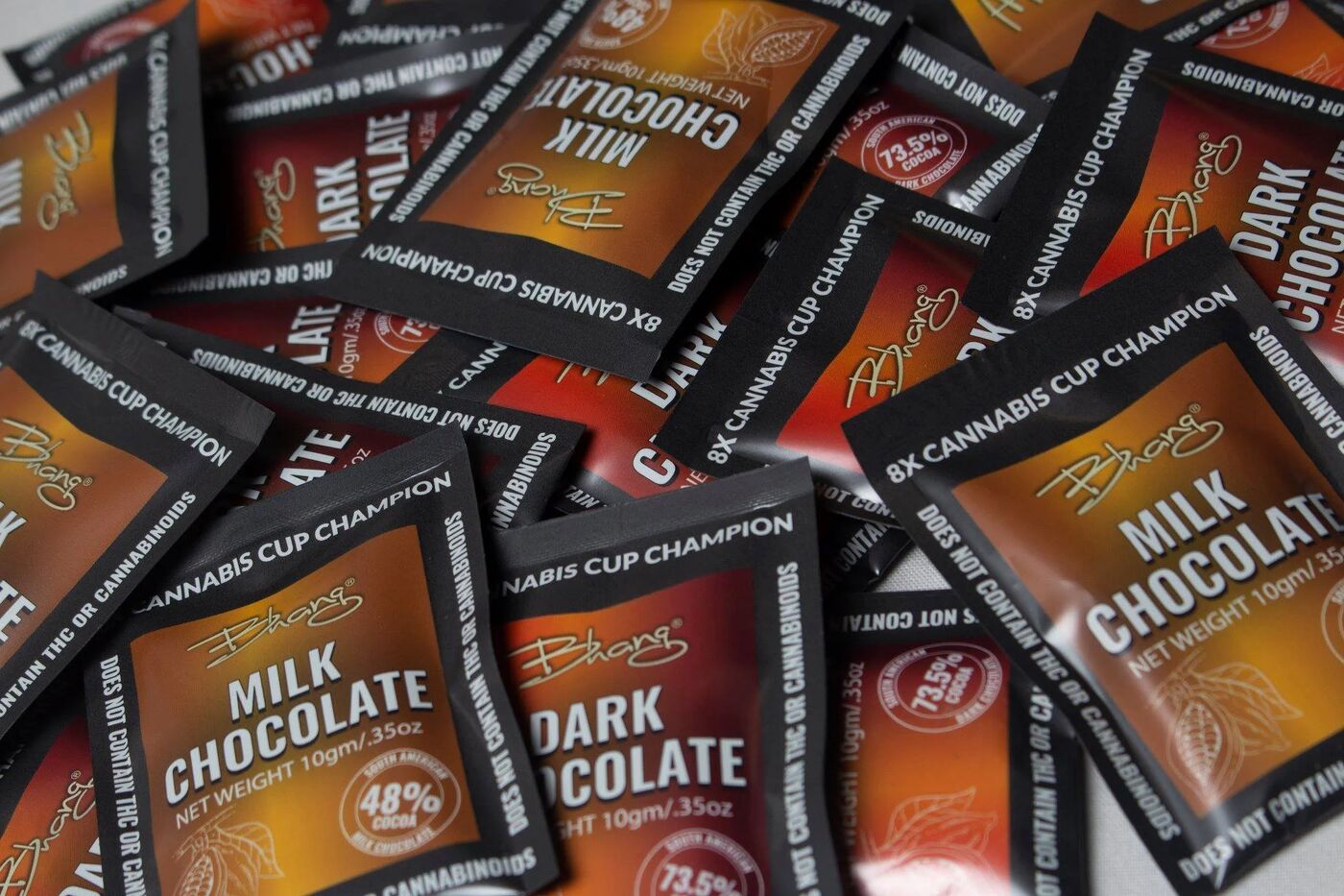 Pile of Bhang milk and dark chocolate bar wrappers labeled Cannabis Cup Champion