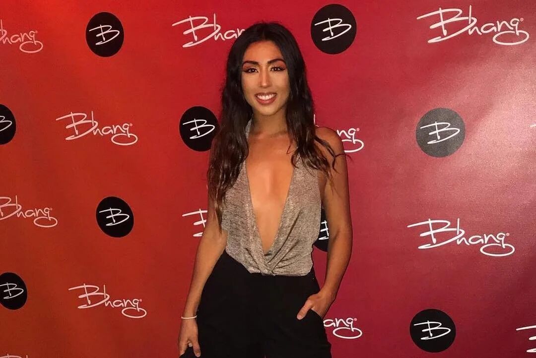 Guest posing in front of the red Bhang step-and-repeat