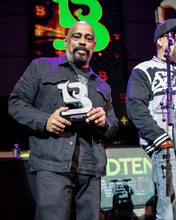 Honoree holding a Budtender Awards trophy on stage