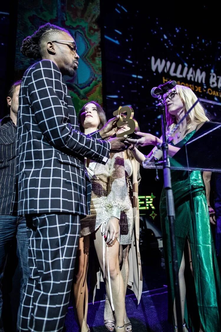 Winners accepting trophies at the Budtender Awards podium