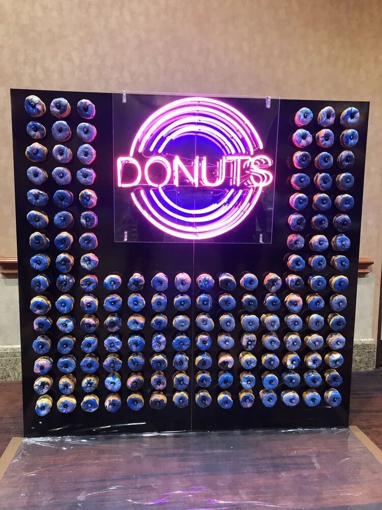 Neon DONUTS sign on a donut wall at the Budtender Awards expo