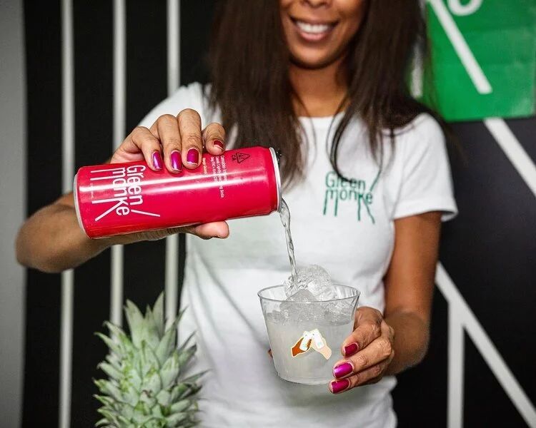 Brand rep pouring a Green Monké drink over ice