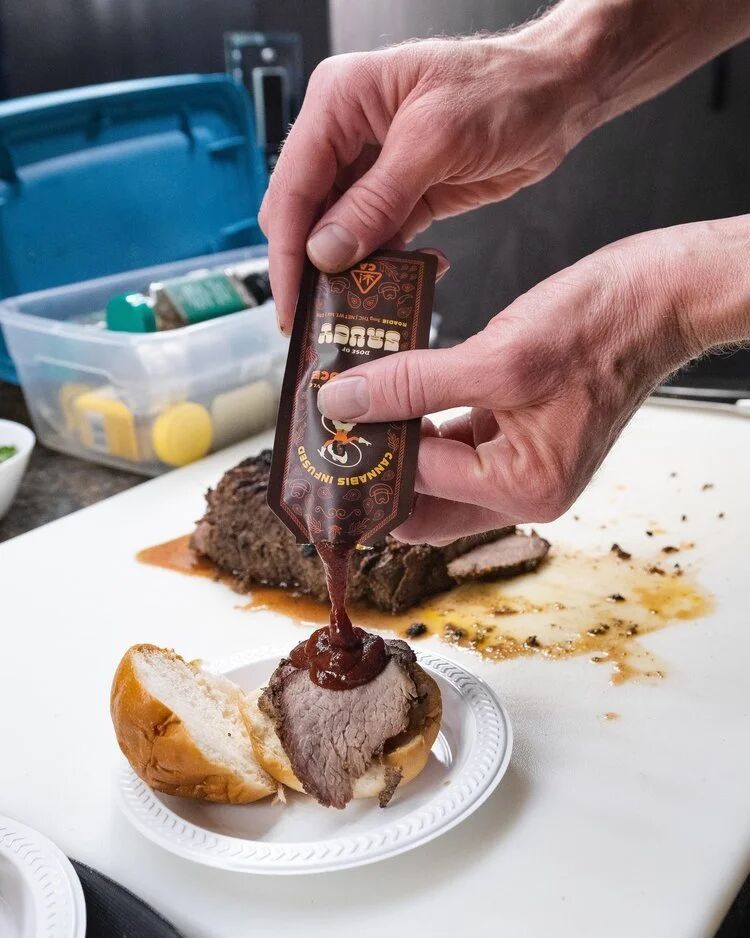 Hand squeezing barbecue sauce over sliced steak at a Budtender Sessions tasting