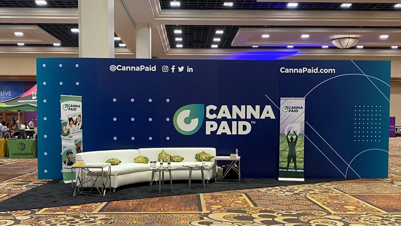 CannaPaid booth with a lounge seating area at G4 Live 2021