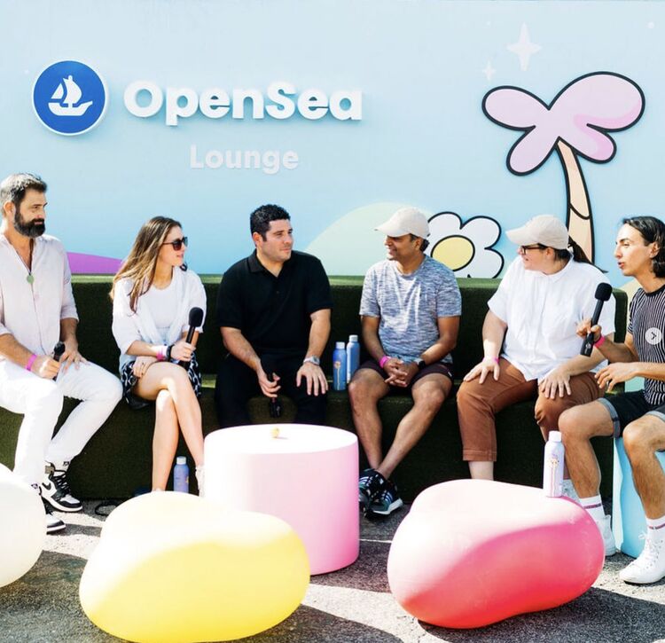Panelists with microphones on colorful cushions in the OpenSea Lounge