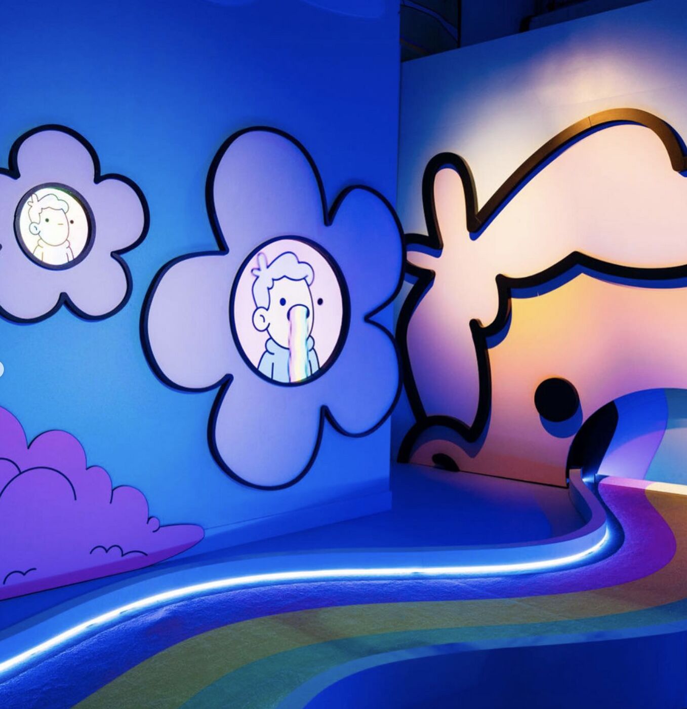 Mini-golf hole with giant cartoon flowers and a neon-lit green