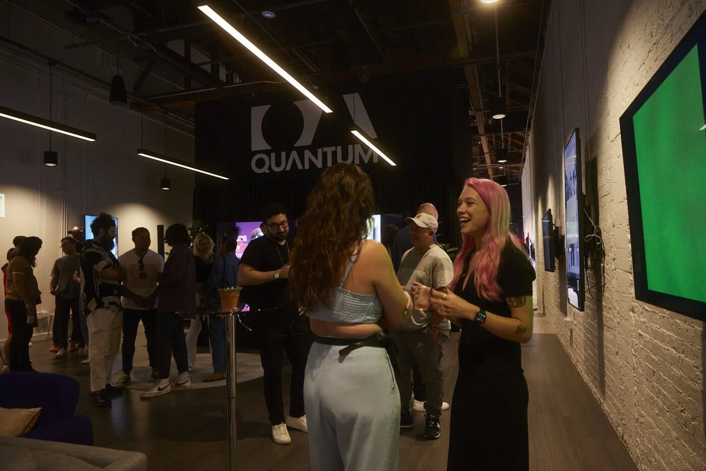 Guests talking near digital art screens at Quantum