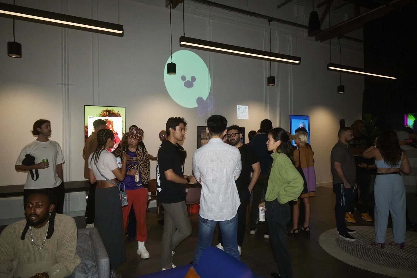 Guests mingling under digital art displays