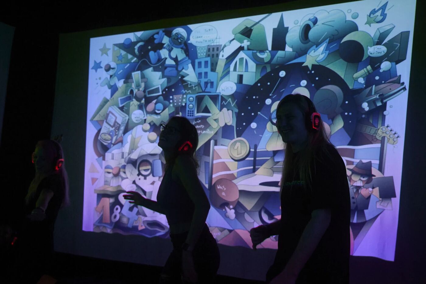 Silent-disco dancers silhouetted against projected art