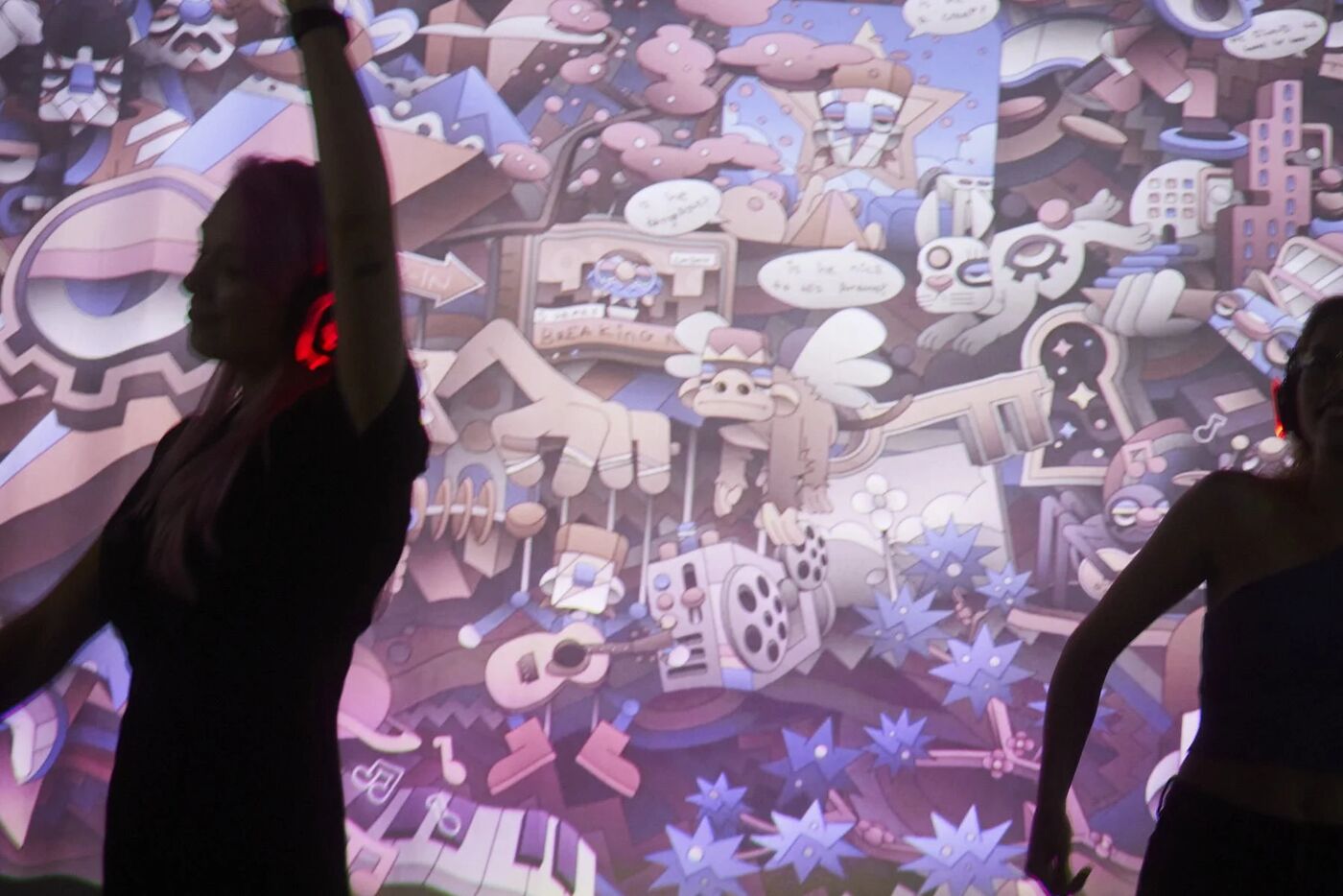 Dancer silhouetted against a colorful projected illustration