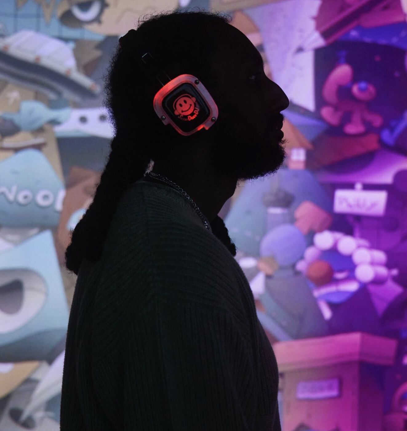 Guest in glowing headphones silhouetted against projected art