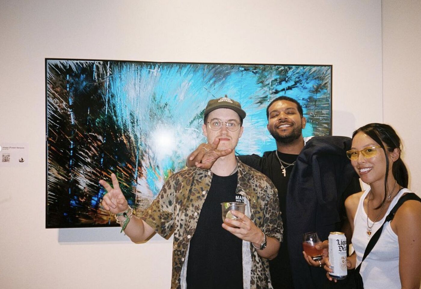 Three guests posing in front of a large digital artwork