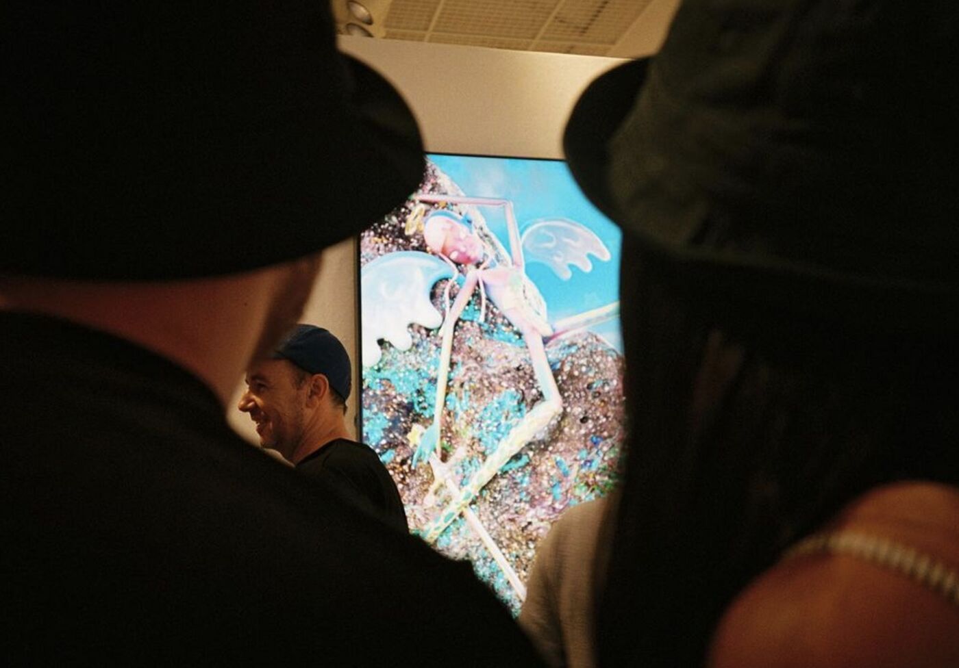 Guests silhouetted in front of a vivid digital artwork