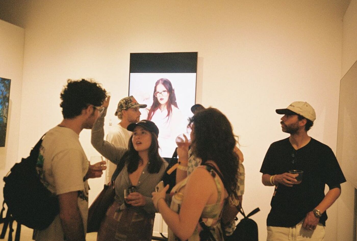 Guests mingling under a portrait artwork in the gallery