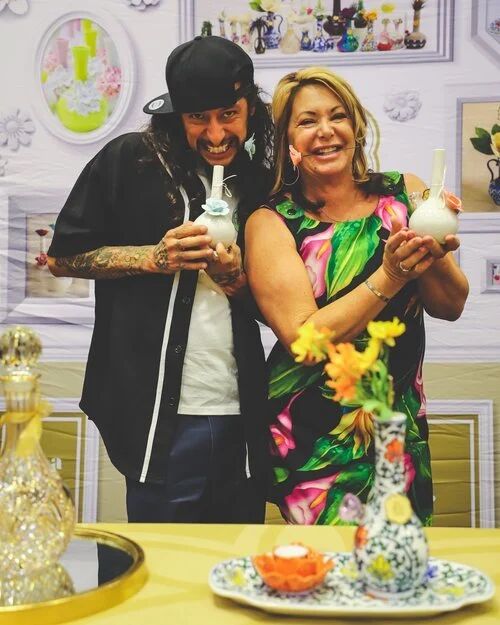 Two attendees holding decorative glass pieces at a G4 Live booth