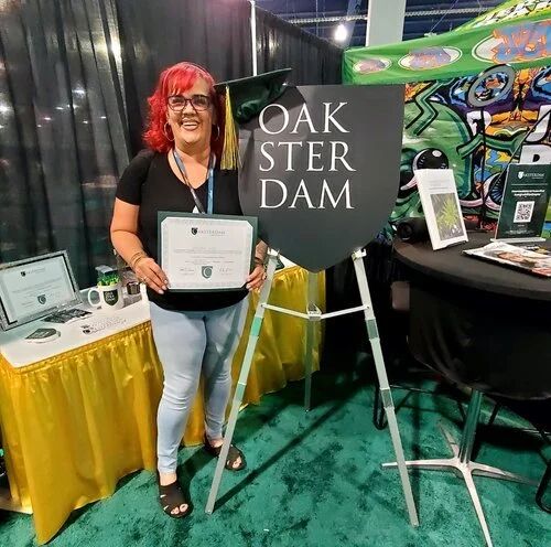 Exhibitor holding a certificate at the Oaksterdam booth
