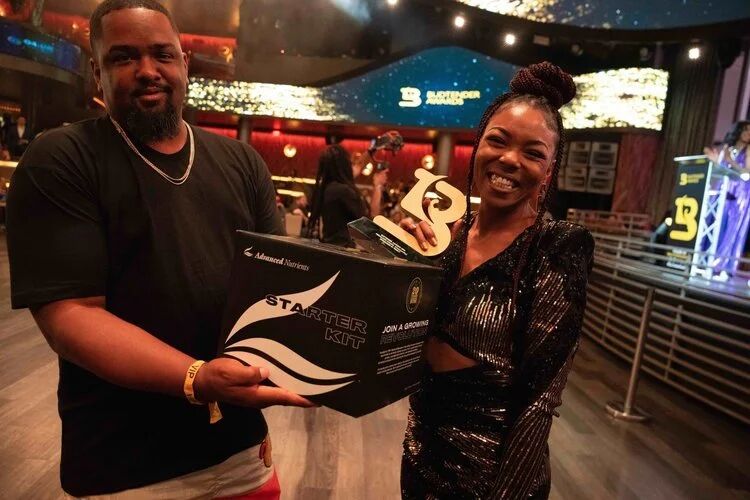 Winner holding a Budtender Awards trophy beside a presenter