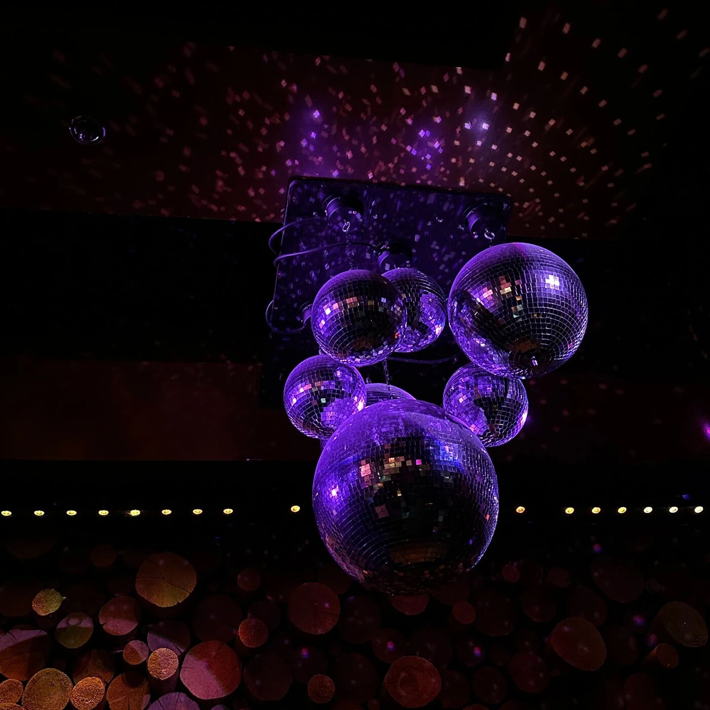 Cluster of purple-lit disco balls above the lounge