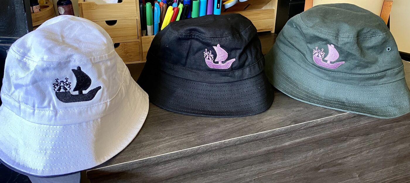Three OpenSea bucket hats in white, black and green