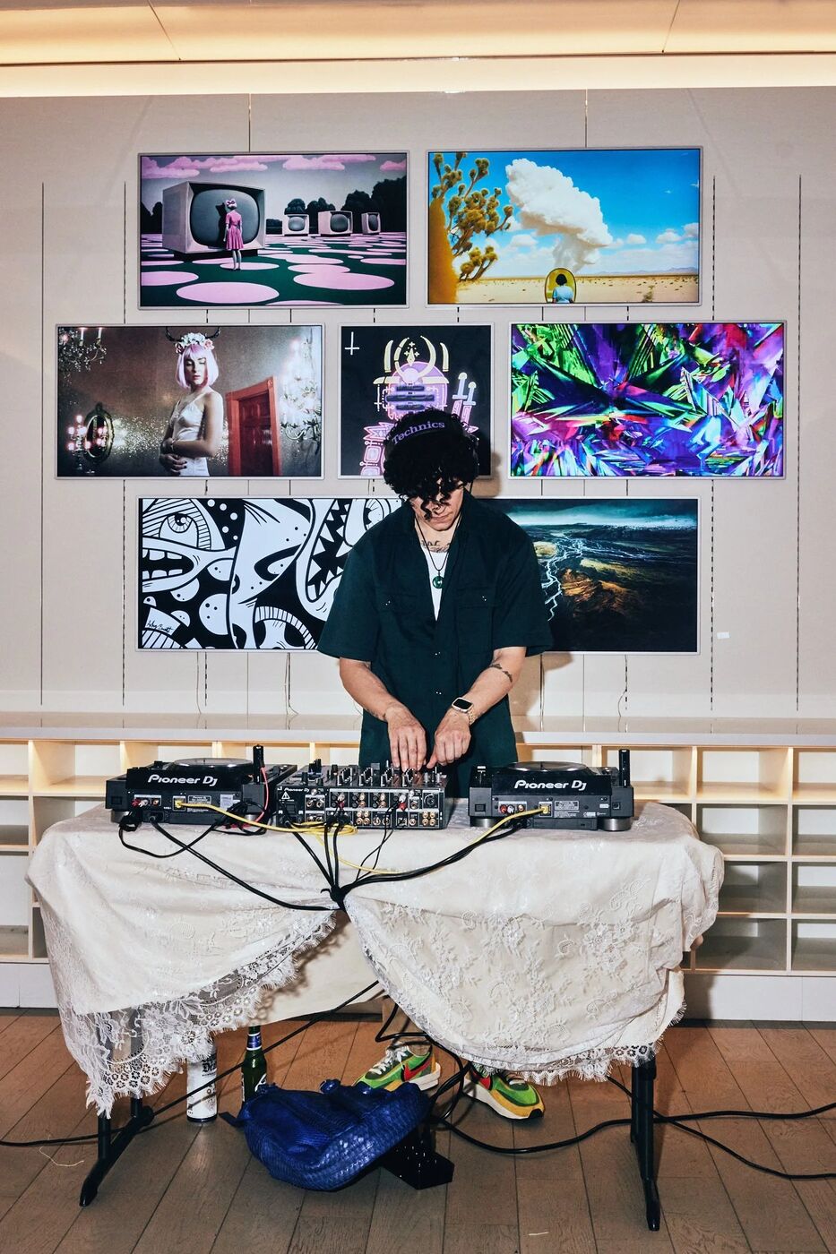 DJ performing in front of a wall of digital art at Pride Perspectives