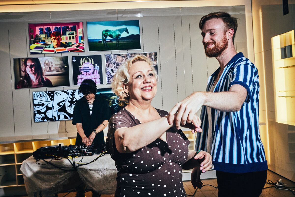 Guests dancing in front of the DJ at the Pride Perspectives gallery