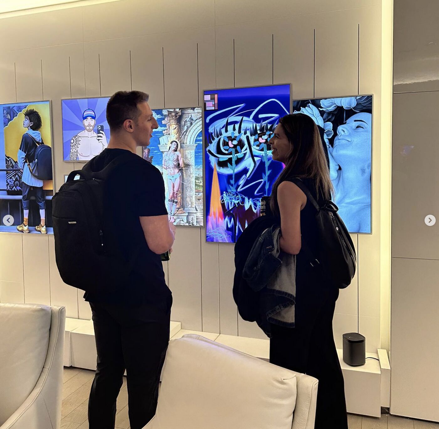 Two visitors viewing the art wall at Pride Perspectives