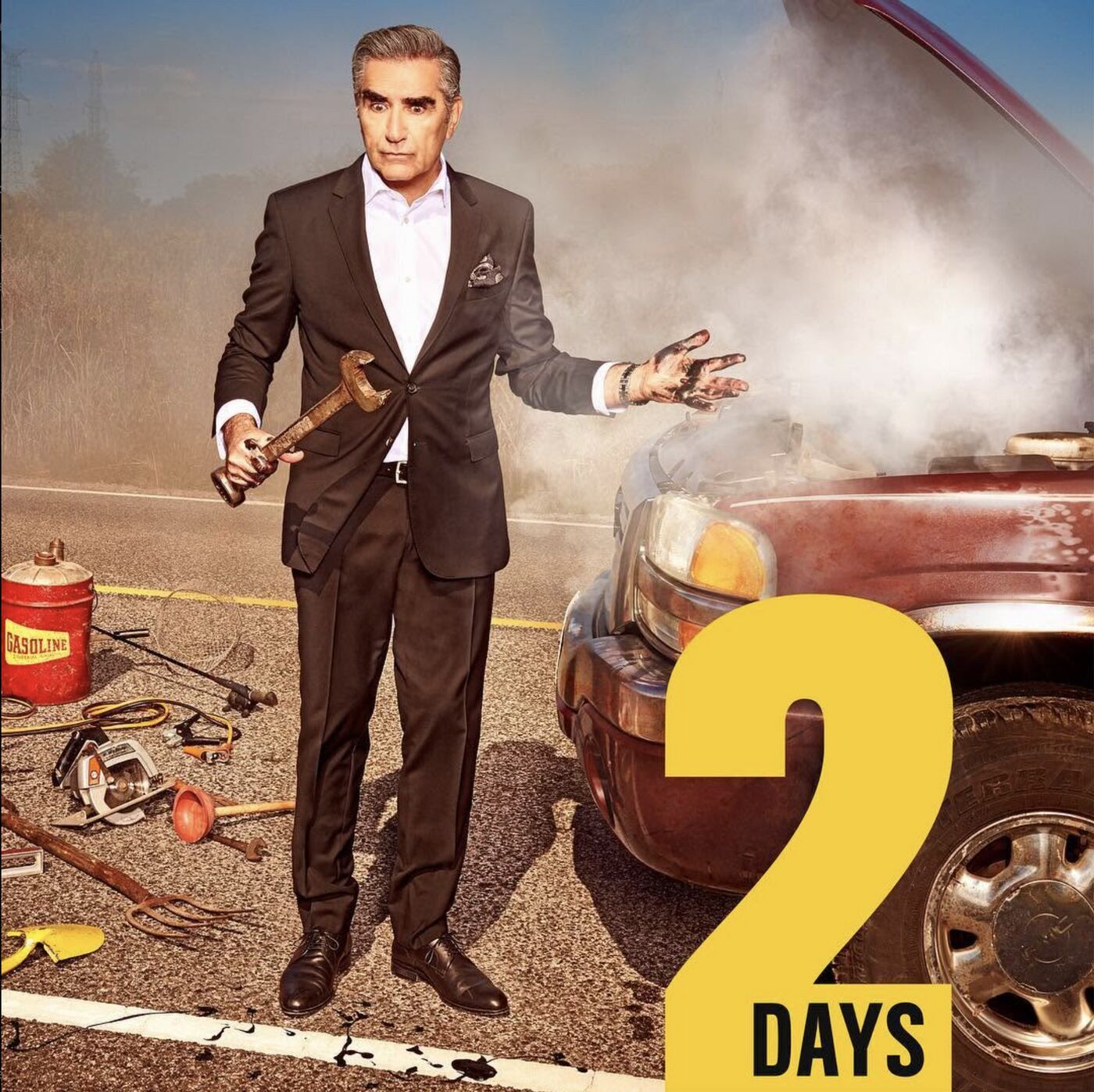 Schitt's Creek countdown: 2 days. A cast member in a suit beside a smoking car