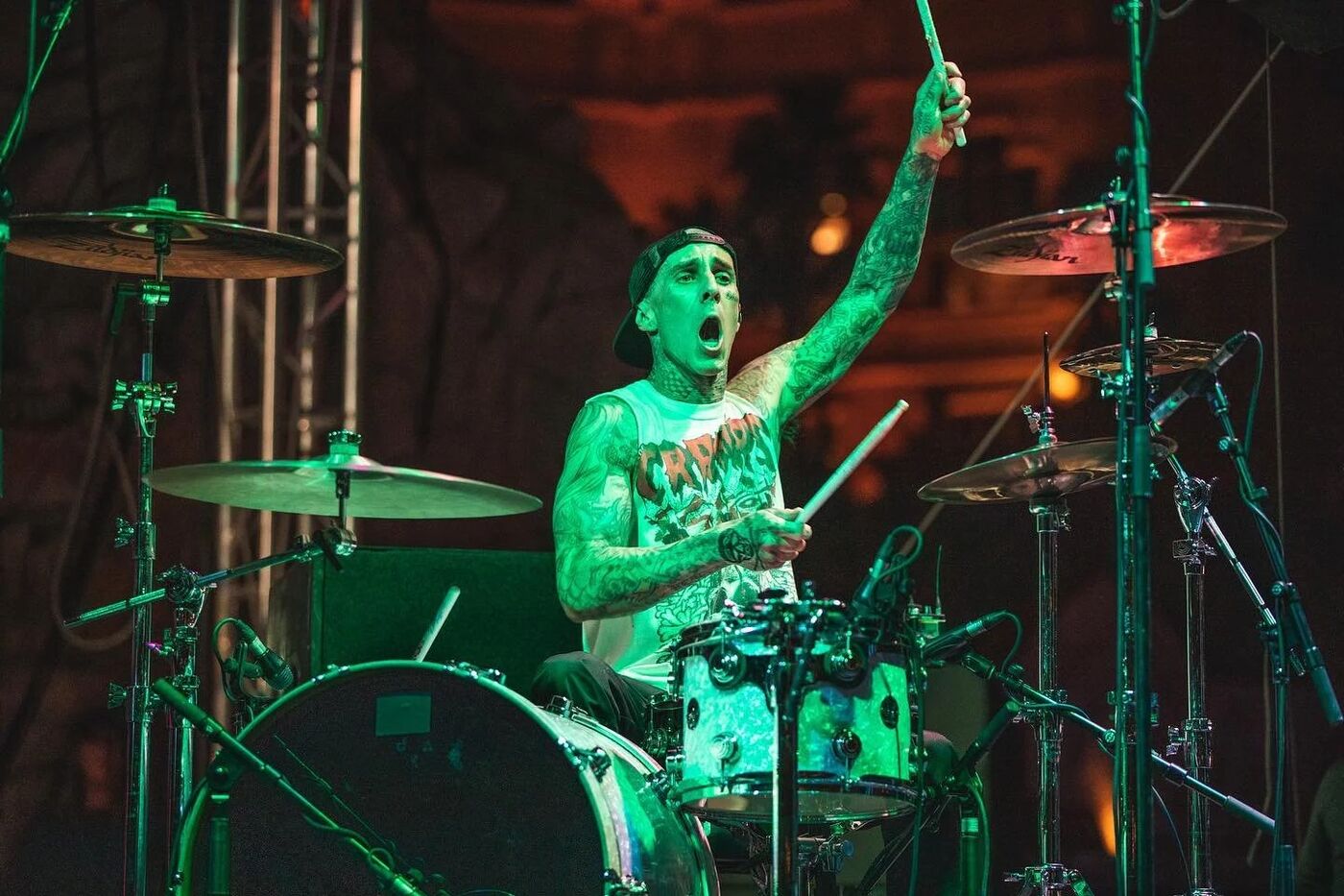 Travis Barker drumming on stage at G4 Live under green lights