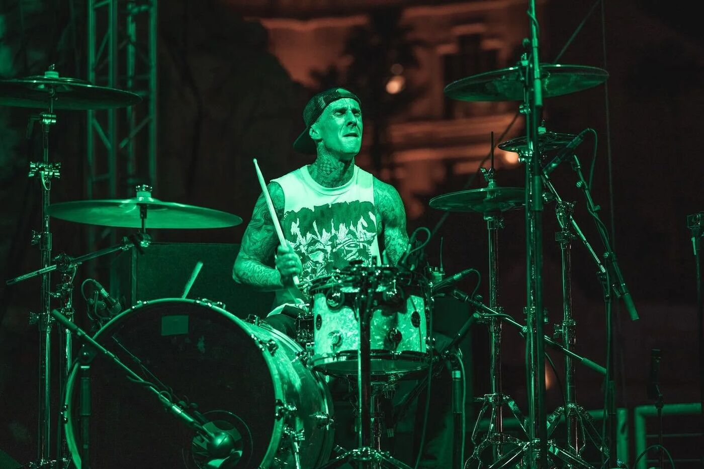 Travis Barker performing on a drum riser at G4 Live