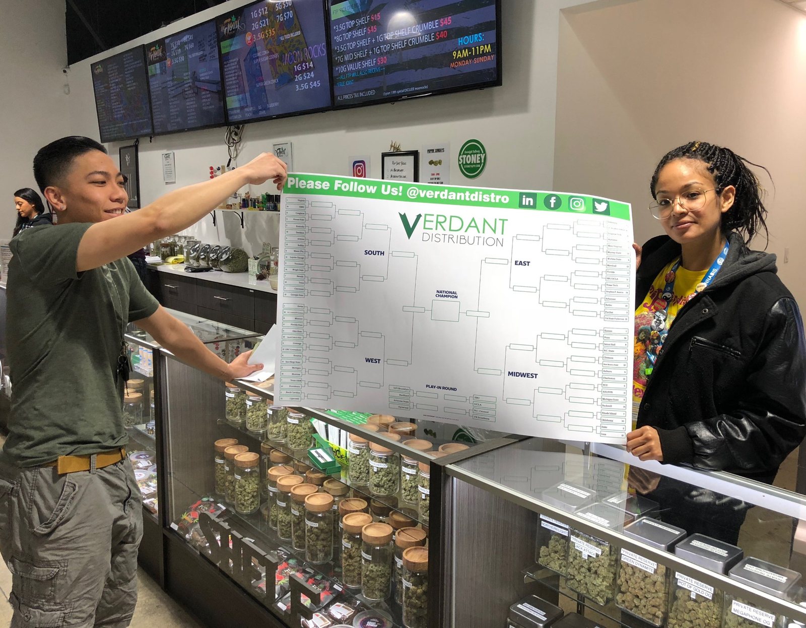 Budtenders holding the Verdant bracket at a dispensary counter