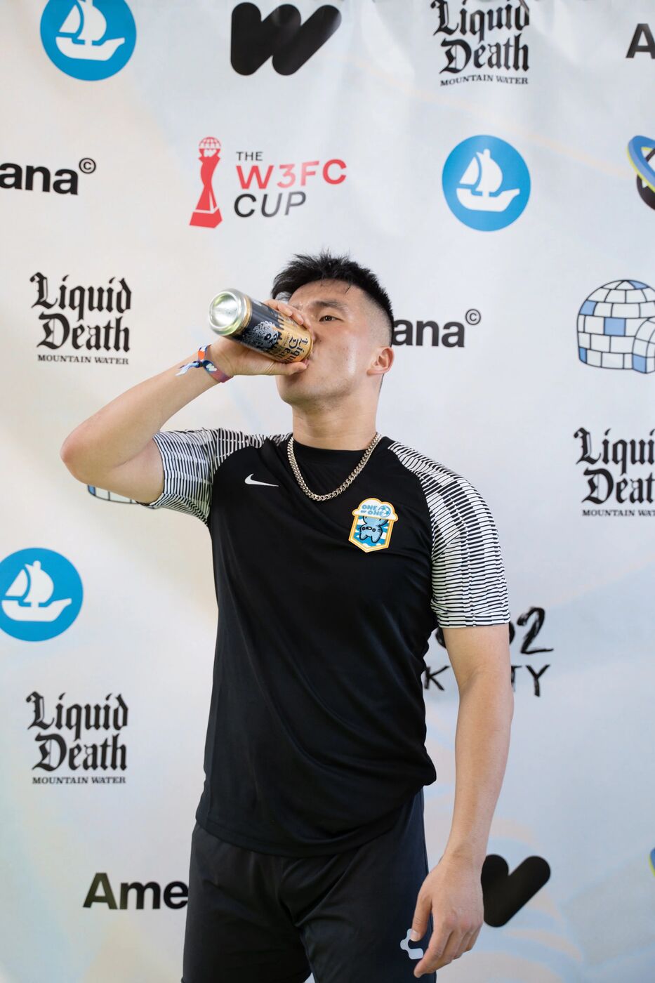 Player drinking a Liquid Death at the W3FC Cup step-and-repeat