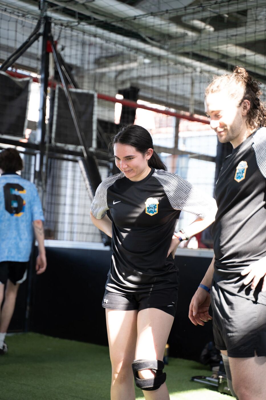 Two players in black W3FC kits smiling on the field