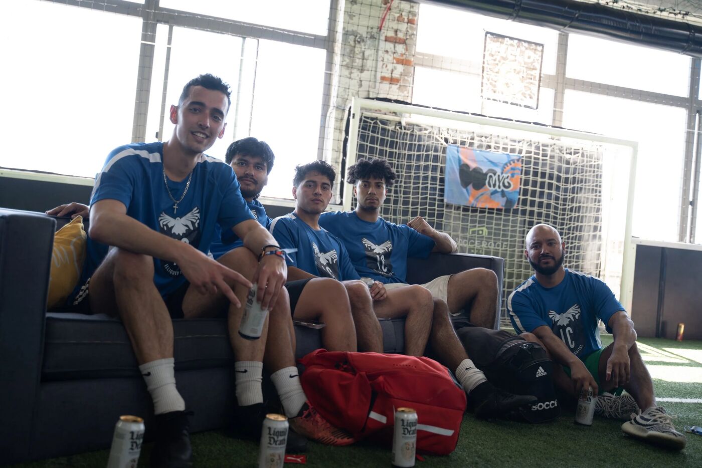 Team in blue kits seated on a couch by the goal