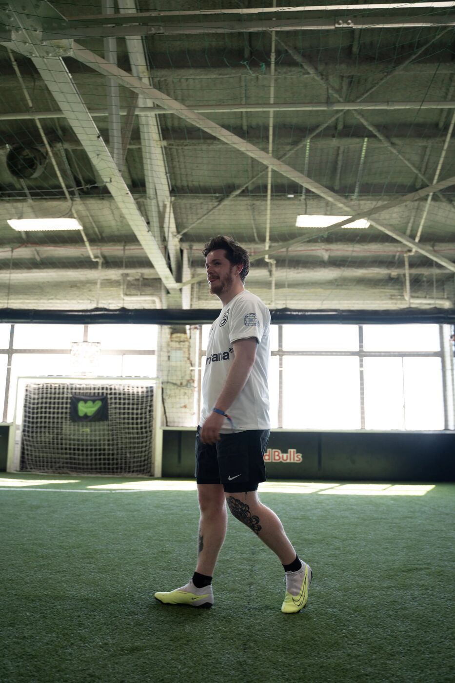 Player in a white kit walking across the indoor pitch
