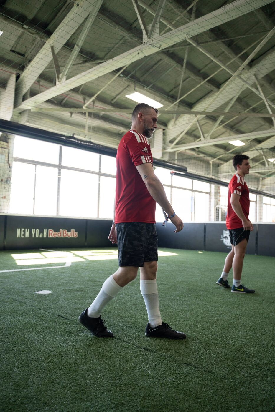 Player in a red kit walking across the indoor pitch