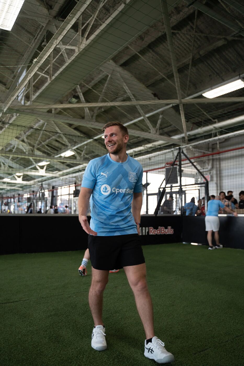Player in an OpenSea jersey laughing on the indoor pitch