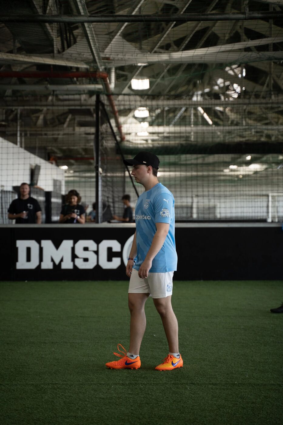 Player in a light blue jersey on the turf near the DMSC wall