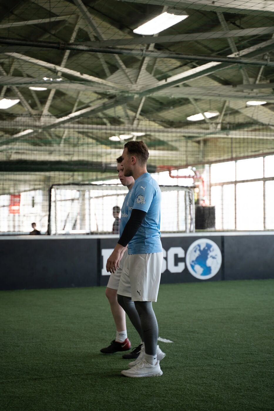 Player in a light blue jersey on the sideline