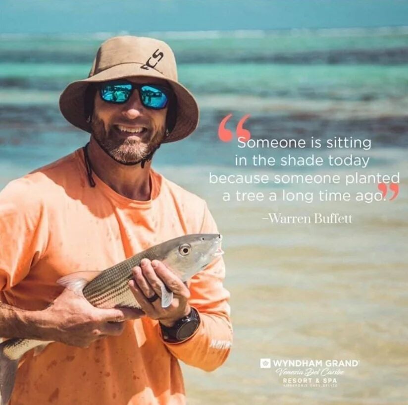 Wyndham Grand Belize quote ad: Someone is sitting in the shade today because someone planted a tree a long time ago, Warren Buffett. Fisherman holding a bonefish